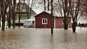 flooded house and shop with rv trailer in between