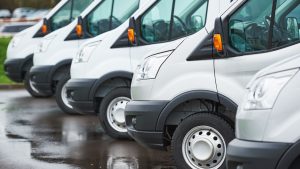 fleet of white commercial vans lined up in a row
