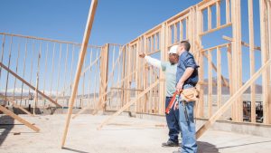 builder and foreman looking at new home build and pointing at issues