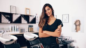 hair stylist holding scissors in hand and smiling