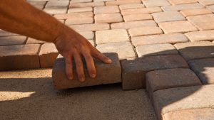 landscaper laying bricks for walk way