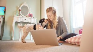girl signing up for pet insurance while snuggling dog