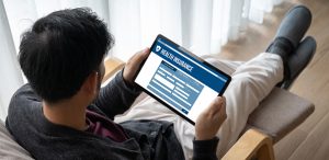 young man looking at health insurance sign up form on tablet